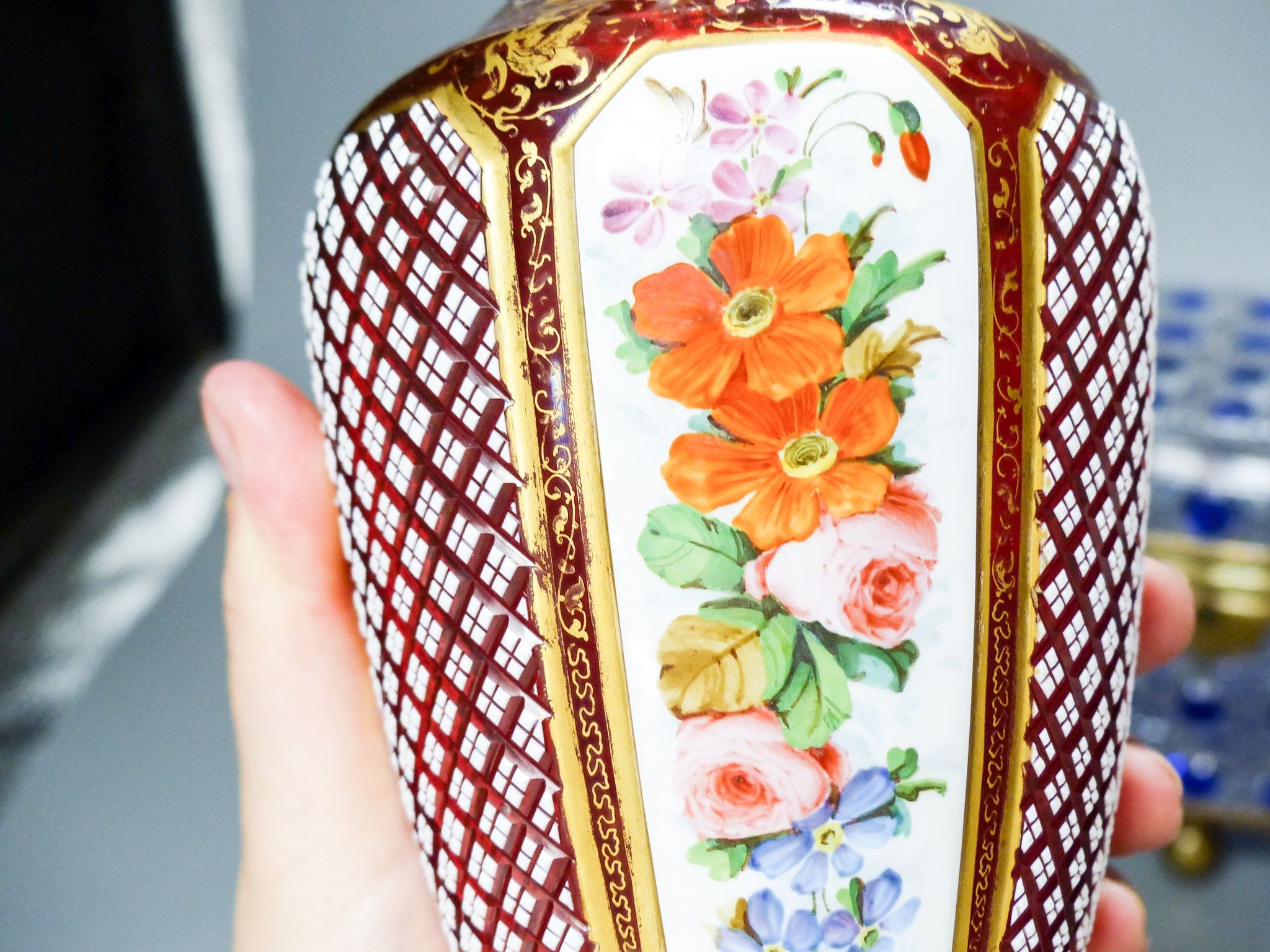 A 19th century Bohemian overlaid glass vase, 25.5cm, a similar gilded and enamelled beaker and two blue flashed hobnail glass biscuit boxes and covers